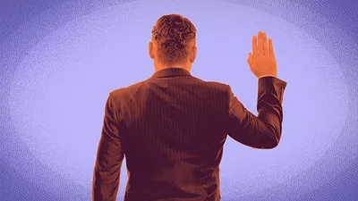 Rear view of a man in a dark suit raising his right hand against a purple gradient background.